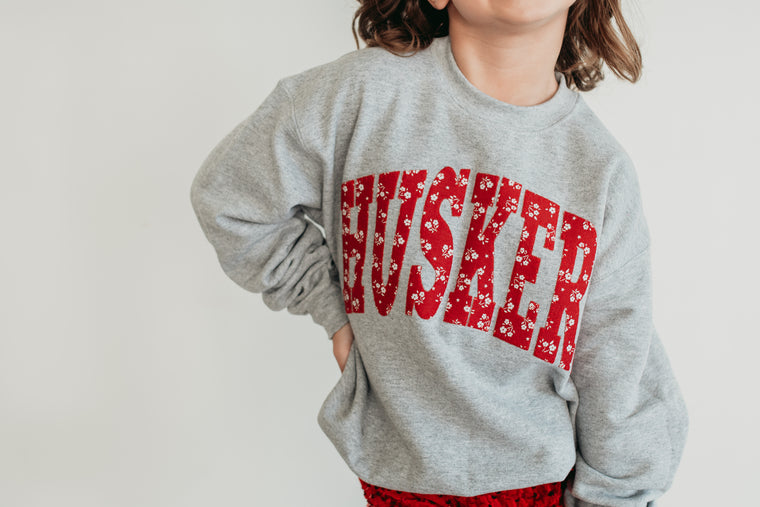 VARSITY RED DAINTY FLORAL HUSKERS - ASH GREY CREWNECK (YOUTH + ADULT)