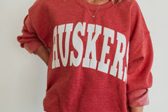 VARSITY WHITE HUSKERS - SCARLET RED CREWNECK