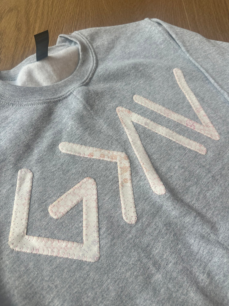 PINK PATCHWORK GOD IS GREATER THAN THE HIGHS AND LOWS SYMBOLS - SPORT GREY CREW