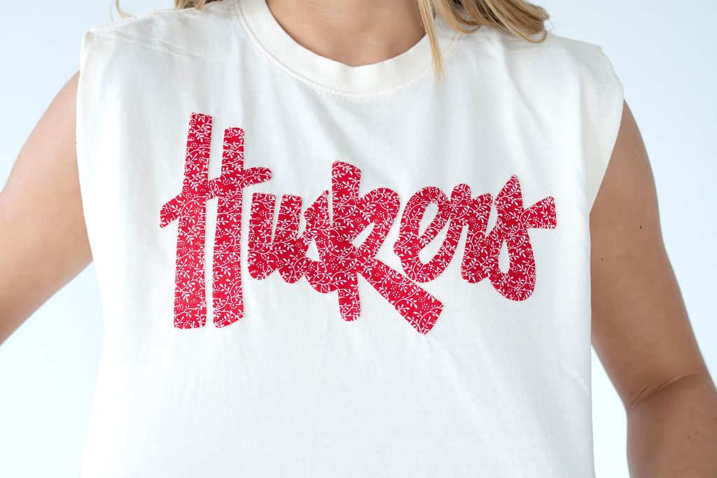 RED DAINTY FLORAL HUSKERS SCRIPT - IVORY MUSCLE TEE