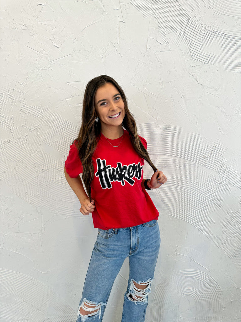 BLACK/ WHITE SPARKLE HUSKERS SCRIPT - RED TEE
