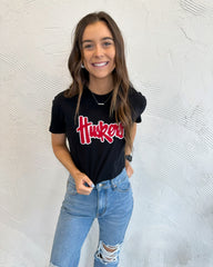 RED/ WHITE SPARKLE HUSKERS SCRIPT - BLACK CROP TEE